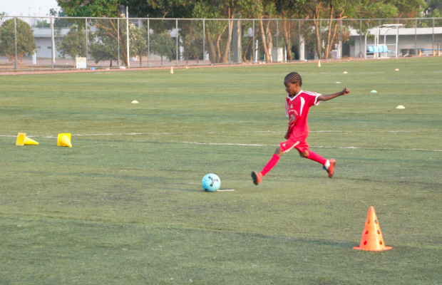 Jeune joueur en train de frapper le ballon